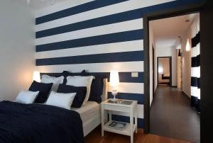 a bedroom with a blue and white striped wall at Luxury villa Lara with private pool in Banjole +12 photos