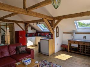 a living room with a couch and a kitchen at Romantic Barn, Private Hot-Tub near Diddly Squat 2 or 3 night stays in Chipping Norton