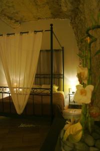 a bedroom with a canopy bed with a flower at Chambres d'Hôtes Troglodytes Le Clos de L'Hermitage in Amboise