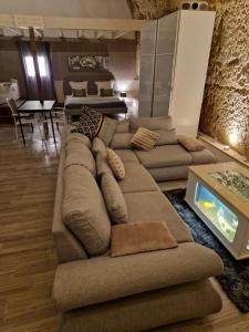 un soggiorno con un grande divano e un tavolo di Chambres d'Hôtes Troglodytes Le Clos de L'Hermitage a Amboise