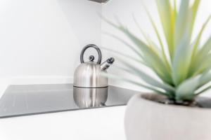 a tea kettle on a counter next to a potted plant at Iate Residence in Portimão