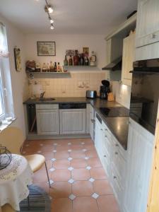 a kitchen with white cabinets and a pink tile floor at Ferienwohnung Dörner in Pirna