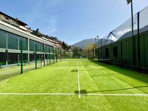 a tennis court with a net on the grass at Andorra Park Hotel in Andorra la Vella