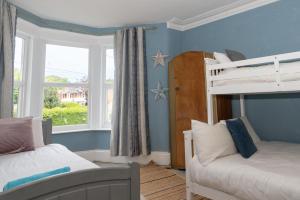 a bedroom with two bunk beds and a window at Belmont Villa in Ilfracombe