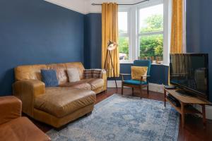 a living room with a couch and a television at Belmont Villa in Ilfracombe