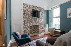 a living room with a fireplace with a tv on a wall at Belmont Villa in Ilfracombe