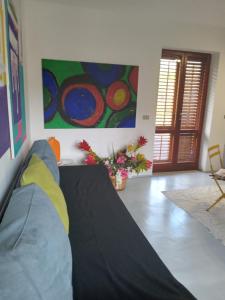 a living room with a couch and a painting on the wall at Casa Vacanze La Tonnara in San Giorgio