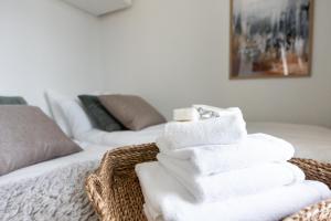 a pile of towels in a basket on a bed at Arctic Taiga Penthouse City Suite in Rovaniemi