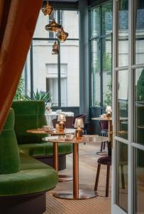 un restaurante con sillas verdes, mesas y ventanas en Chateau De Rochecotte, en Saint-Patrice