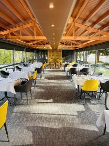 a dining room with tables and yellow chairs at Andorra Park Hotel in Andorra la Vella