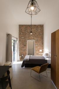 a bedroom with a bed and a brick wall at the greenhouse apartment in Mount Road