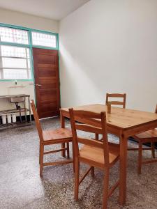 a wooden table and chairs in a room with a piano at 老宅小巷6人包棟民宿 in Taitung City