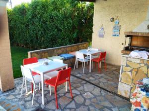 een patio met 2 tafels en stoelen en een open haard bij CHA Nanakas Village Inn in Corfu-stad