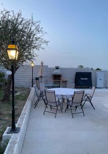 patio con mesa, sillas y luz de la calle en Casa con piscina, Villa Alarilla, en Fuentidueña de Tajo