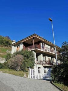a large house with a white fence and a street light at Bluelake Apartament 1 Omegna in Omegna