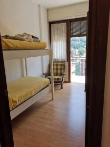 a room with two bunk beds and a balcony at Bluelake Apartament 1 Omegna in Omegna