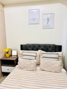 - une chambre avec un lit doté d'une tête de lit et d'oreillers noirs dans l'établissement Jazz Residences - Cozy 1 Bedroom Condo for 4 in Makati, à Manille