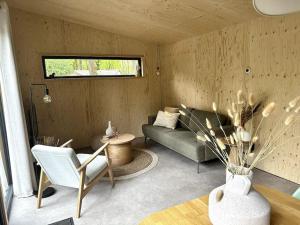 een woonkamer met een bank en een tafel bij FIKA Luxe vakantiewoning voor 4 personen @ Veluwe in Hoenderloo