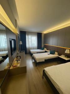 ein Hotelzimmer mit 2 Betten und einem TV in der Unterkunft Ring Downtown Hotel in Antalya