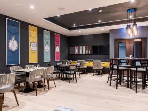 a restaurant with tables and chairs and a clock on the wall at Premier Inn München City Zentrum in Munich