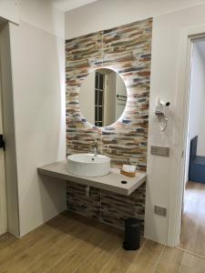 un bagno con lavandino e specchio di Rosa Rooms Pompei a Pompei