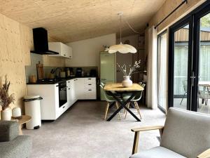 a kitchen and dining room with a table in it at FIKA Luxe vakantiewoning voor 4 personen @ Veluwe in Hoenderloo