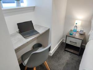 een slaapkamer met een bureau met een laptop en een stoel bij City Centre Premier Top Floor Executive 2 Bed Apartment in Sunderland