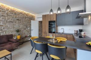 a kitchen and living room with a table and chairs at APARTMAN BORGO MARINA - by the sea in Rijeka
