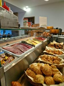 a buffet line with different types of bread and pastries at Medos Hotel in Budapest