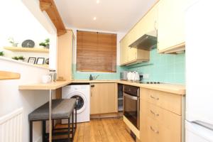 a kitchen with a washer and dryer in it at Beautiful one bed garden flat in Muswell hill in London +16 photos