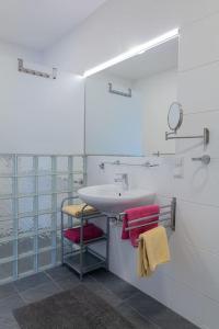 uma casa de banho com lavatório e toalhas vermelhas em Spacious, quiet 4 room flat em Salzburgo