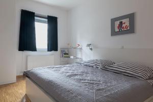 um quarto com uma cama com um edredão azul e uma janela em Spacious, quiet 4 room flat em Salzburgo