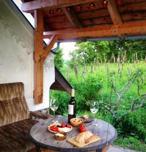 una mesa con una botella de vino y algo de comida en Présház szállás a Szent György-hegyen, en Kisapáti