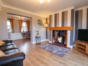 a living room with a couch and a fireplace at Saddle Rack Cottage in Louth