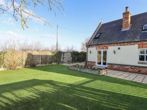 a house with a large lawn in front of it at Saddle Rack Cottage in Louth