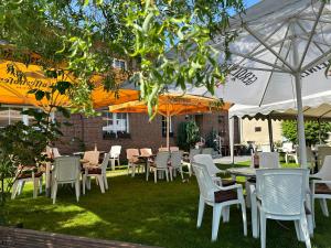 a group of tables and chairs under umbrellas at Landhotel & Restaurant "Fahrenkamp" in Röwitz