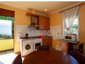 a kitchen with a table and a stove and a microwave at Casa Vacacional Vigo Planta Alta in Vigo