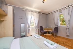 Bella Vista في Čunski: غرفة نوم بسرير كبير مع كرسيين ومكتب