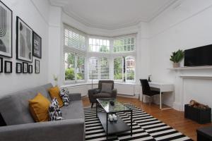 uma sala de estar com um sofá e uma lareira em Beautiful one bed garden flat in Muswell hill em Londres