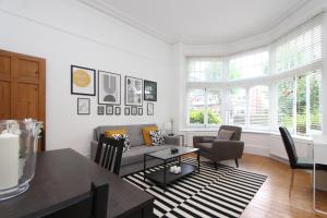 uma sala de estar com um sofá e uma mesa em Beautiful one bed garden flat in Muswell hill em Londres
