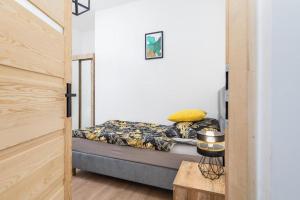 una piccola camera con un letto in una stanza di Bm apartamenty Wały Chrobrego Radogoska Parking a Stettino