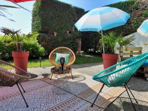 eine Terrasse mit 2 Stühlen und einem Sonnenschirm in der Unterkunft Campanile Metz Est Technopole - Restaurant in Metz