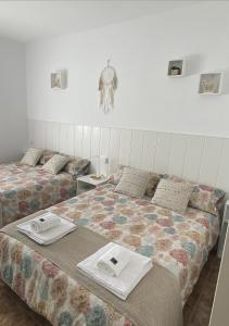 a bedroom with two beds with towels on them at Casa con piscina, Villa Alarilla in Fuentidueña de Tajo