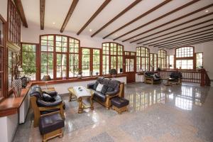 a large living room with chairs and tables and windows at KAISERHOF Krynica Morska in Krynica Morska