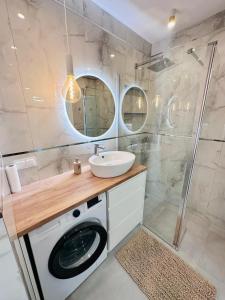 a bathroom with a washing machine and a sink at Apartament Nadmorski in Gdańsk