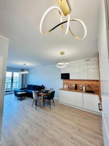 a kitchen and living room with a table and chairs at Apartament Nadmorski in Gdańsk