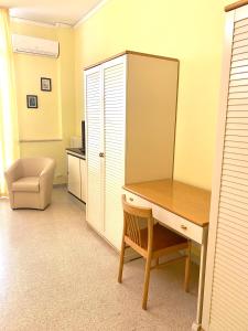 een kamer met een bureau, een stoel en een kast bij OSTELLO MADRE SANTINA in Lecce