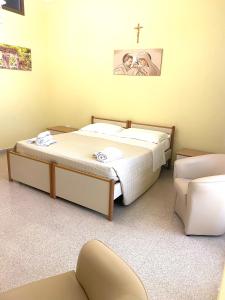 1 dormitorio con 1 cama y 1 cruz en la pared en OSTELLO MADRE SANTINA en Lecce