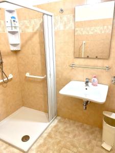 een badkamer met een douche en een wastafel bij OSTELLO MADRE SANTINA in Lecce