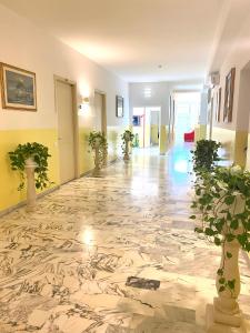 a hallway with a marble floor with potted plants at OSTELLO MADRE SANTINA in Lecce